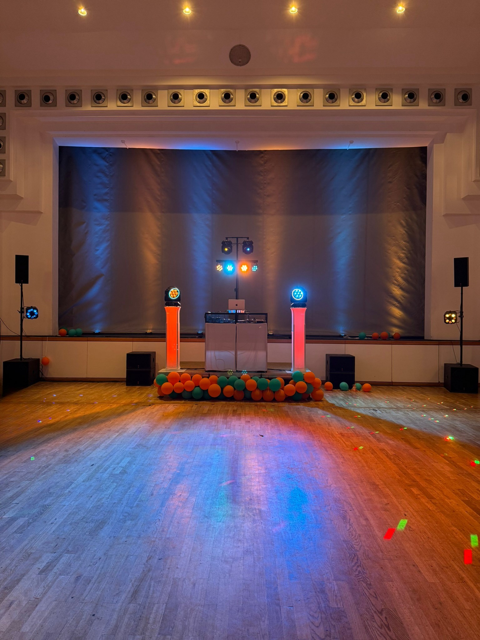 DJ-Setup auf einer Bühne mit farbiger Beleuchtung